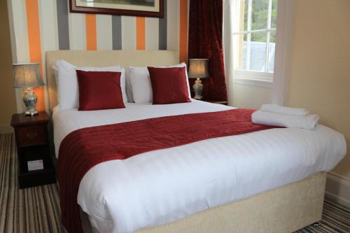 
a hotel room with a bed and a dresser at Gairloch Hotel 'A Bespoke Hotel' in Gairloch
