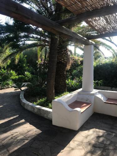 a white bench sitting under a pergola at Casa Schicciola in Stromboli