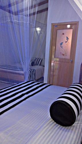 a bedroom with a bed with a black and white comforter at Cozy Homestay Waterfall Road Ella in Ella