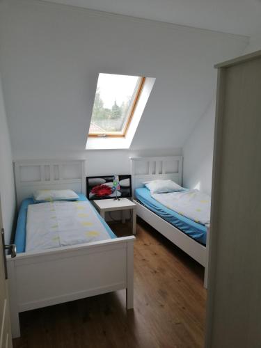 two beds in a room with a window at Fenyves Ferienhaus 2 **** in Balatonfenyves