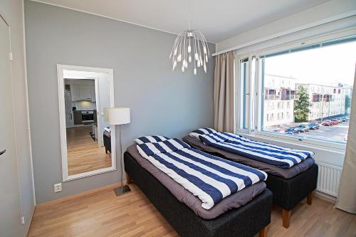 Duas camas num quarto com uma janela grande em Pro Apartments 5 em Vaasa