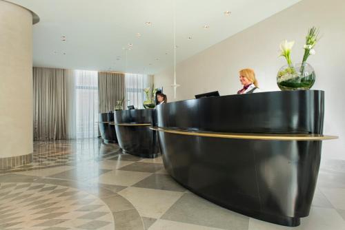 a lobby with a row of black chairs at Crowne Plaza Berlin - Potsdamer Platz, an IHG Hotel in Berlin