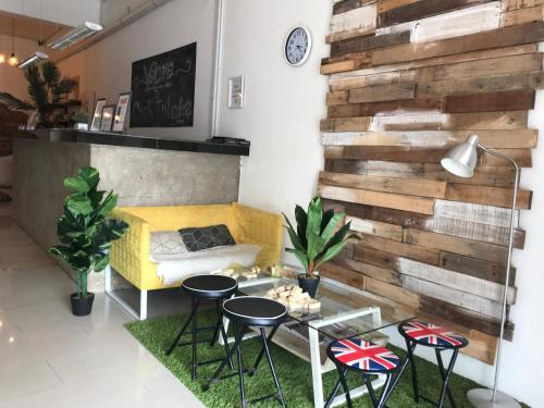 a room with a wooden wall with a table and chairs at Check In Lodge in Kuching