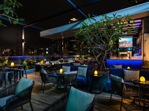 a restaurant with a view of the city at night at Tastoria Collection Sukhumvit in Bangkok