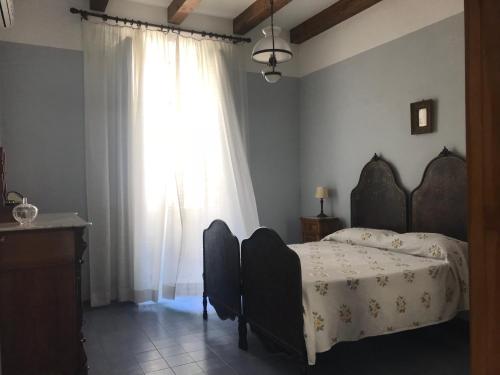 Un dormitorio con una cama y una ventana grande. en Palazzo Tocco, en Tropea