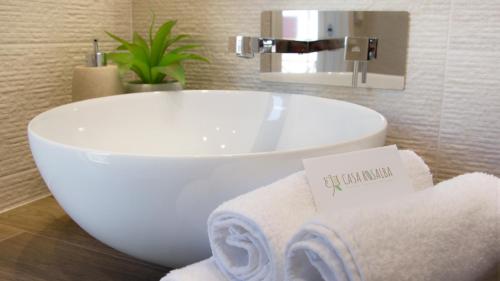 une salle de bain avec un lavabo blanc et des serviettes dans l'établissement Casa Rosalba, à Grottaglie