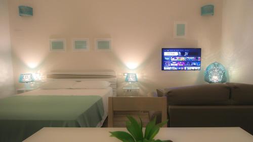 - une chambre avec 2 lits, un canapé et une télévision dans l'établissement Casa Rosalba, à Grottaglie