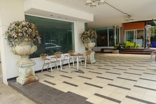 a lobby with chairs and vases on the floor at Fenix in Pathum Thani