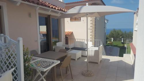 une terrasse avec un parasol, une table et des chaises dans l'établissement Appartamenti Borgo Panoramico N 4, à Tropea