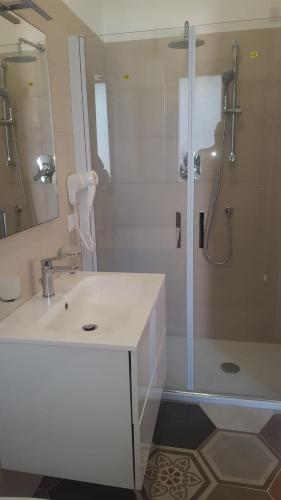 a bathroom with a white sink and a shower at Appartamenti Borgo Panoramico N 4 in Tropea