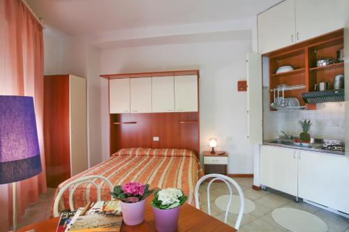 リミニにあるResidence Aurigaのベッドルーム1室(ベッド1台、花のテーブル付)