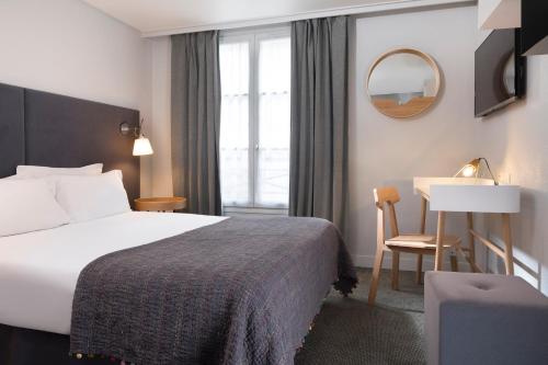 une chambre d'hôtel avec un lit et un bureau dans l'établissement Hotel d'Espagne, à Paris