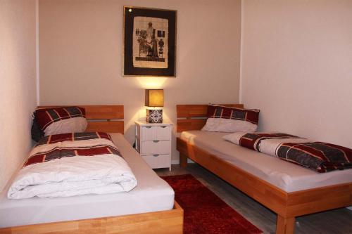 a bedroom with two beds and a night stand with a lamp at Ferienwohnung Melanie in Hart im Zillertal