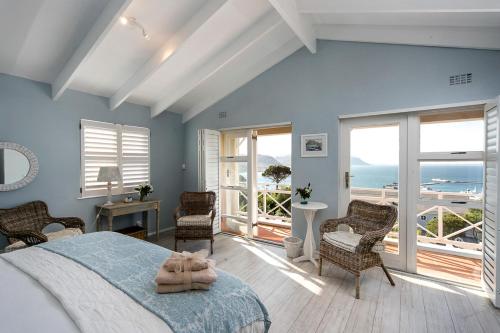 a bedroom with a bed and a view of the ocean at Dolphin Cottage in Simonʼs Town