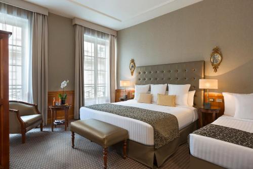 une chambre d'hôtel avec deux lits et une chaise dans l'établissement Meliá Paris Vendôme, à Paris
