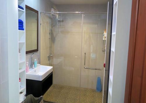 a bathroom with a glass shower and a sink at Bali Residence in Mae Pim