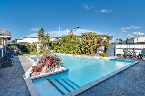 a swimming pool with plants in a yard at Gardner Court Motel in Napier