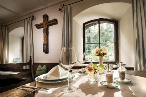 a dining room with a table with a cross on the wall at Naturidyll Hotel Hammerschmiede in Anthering