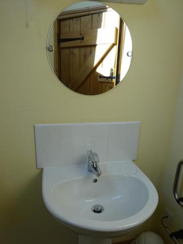 a bathroom with a white sink and a mirror at The Old Farmhouse in Milton Keynes