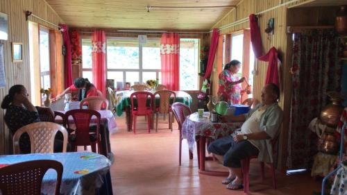 un gruppo di persone seduti ai tavoli in un ristorante di Vamoose LIPPOHOCHHA HOMESTAY a Sombāri