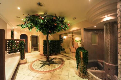 a lobby with a tree in the middle of a room at Alphotel Garni Salner in Ischgl