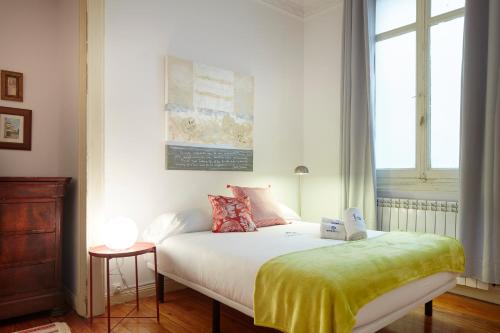 ein Schlafzimmer mit einem Bett mit einer gelben Decke darauf in der Unterkunft Udare - Basque Stay in San Sebastián