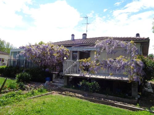 a house with purple flowers on a fence at 5 Cité Creve Coeur in Manciet