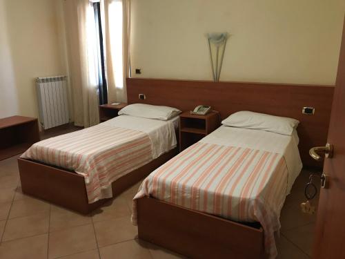 um quarto de hotel com duas camas e uma janela em Hotel Bucolia em Lamezia Terme