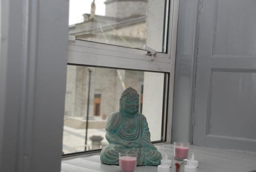 a statue sitting on a window sill with candles at Tranquility in Longford