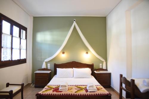 a bedroom with a large bed with a pointed headboard at Archontiko Klitsa in Portariá