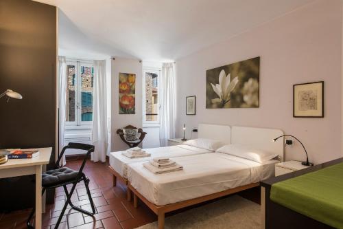 - une chambre avec un lit blanc et un bureau dans l'établissement Apartments Florence - Duomo, à Florence