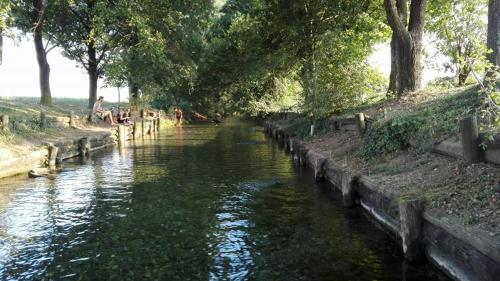 a river with people sitting on the side of it at B&B delle Arti in Crema
