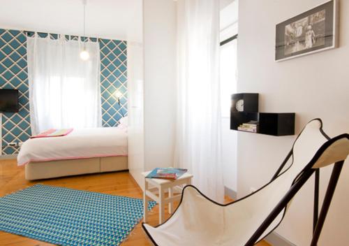 a bedroom with a bed and a chair and a table at Mouraria Deluxe Apartments in Lisbon
