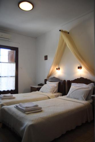 een slaapkamer met 2 bedden en een raam bij Archontiko Klitsa in Portariá
