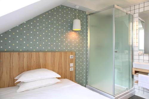 a bedroom with a bed with a glass shower at Hôtel et Apparts Marin in Laval