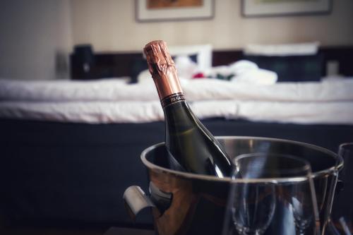 a bottle of wine in a bucket on a table at Hotel Verso in Jyväskylä