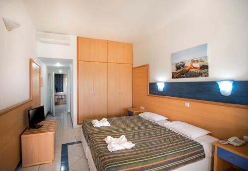 a hotel room with a bed and a television at Eurovillage Achilleas Hotel in Mastichari