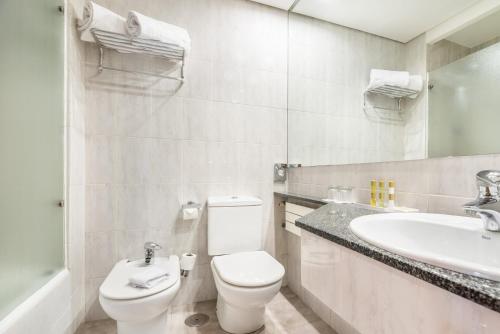 a bathroom with a toilet a sink and a bathtub at Eurostars Atlántico in A Coruña