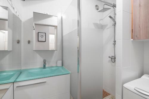 a bathroom with a glass shower and a sink at L'Aurore by Cocoonr in Saint Malo