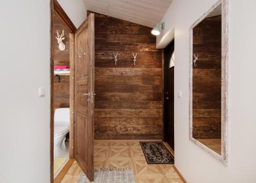 a bathroom with a toilet and a wooden wall at Cute apartment, next to old town, with free parking in Tallinn