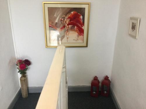 a stairway with a painting on the wall and red shoes at Tranquility in Longford