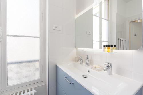 a white bathroom with a sink and a mirror at Maison de Lignières - Guest House - Paris quartier Champs-Elysées in Paris