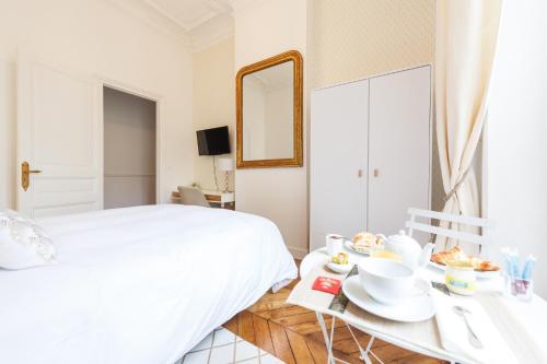 a bedroom with a bed and a table with food on it at Maison de Lignières - Bed & Breakfast - Paris quartier Champs-Elysées in Paris