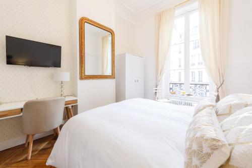 a white bedroom with a bed and a desk and a mirror at Maison de Lignières - Bed & Breakfast - Paris quartier Champs-Elysées in Paris