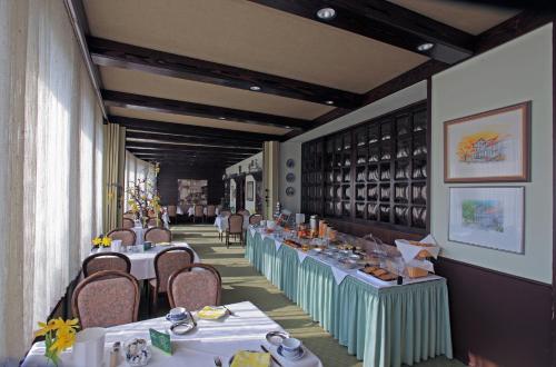 a dining room with tables and chairs and wine bottles at Lampes Posthotel in Grünenplan