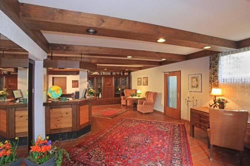 a large living room with a desk and a rug at Lampes Posthotel in Grünenplan