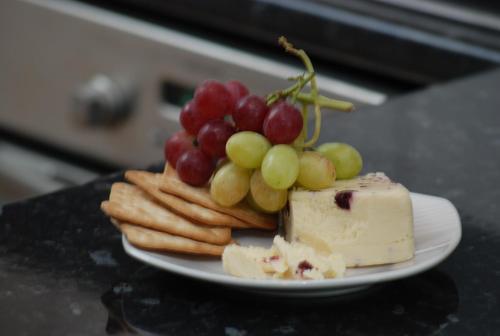 a plate of cheese and grapes and bread on a table at Tranquility in Longford