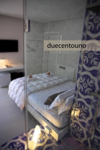 a glass shelf with a bed in a room at Locanda del Bagatto in Milazzo