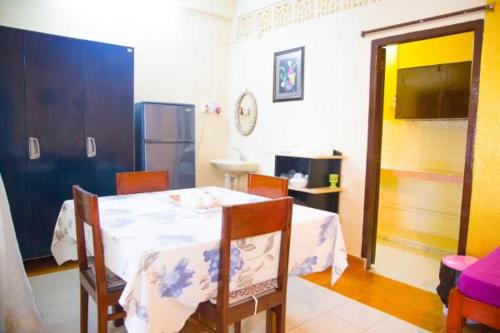 comedor con mesa y sillas y cocina en Edha Homestay en Port Blair