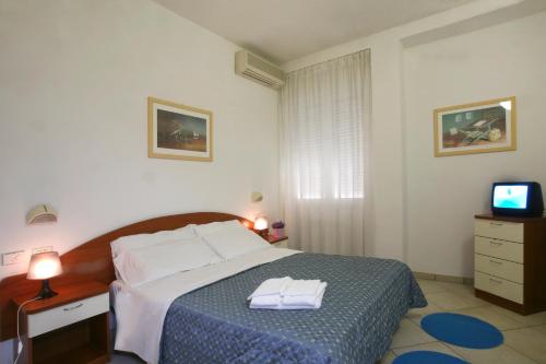 Residence I Girasoli في ريميني: غرفة نوم عليها سرير وفوط